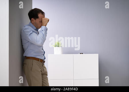 Side View Of A Stressed Businessman Standing In Office Stock Photo