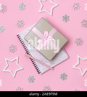 Christmas winter celebration concept. Marble notepad with pen and gift on pink background Stock Photo