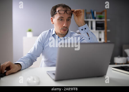 Shocked Businessman Looking At Laptop Screen In Office Stock Photo