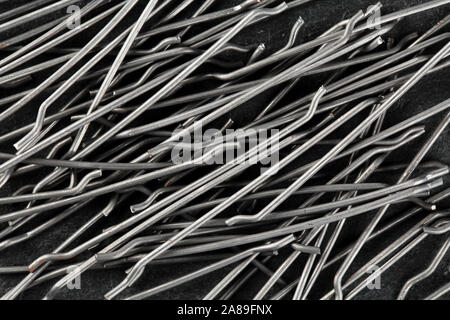 Extreme close up, top down view of end hooked steel macro fibers for concrete reinforcement. Construction industry background Stock Photo