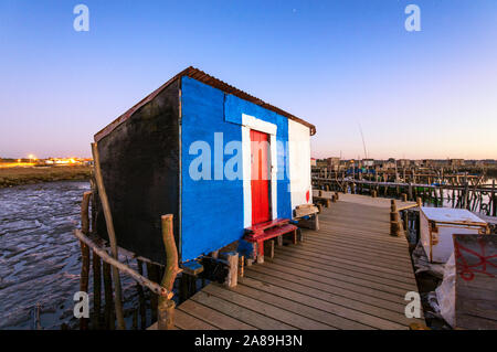 A fisherman hut on a wooden pillars pier, the palafite fishing harbour of Carrasqueira at dusk. Alentejo, Portugal Stock Photo