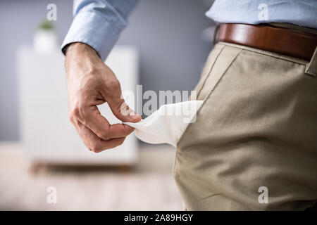Close-up Of Young Man Showing Empty Pockets Stock Photo