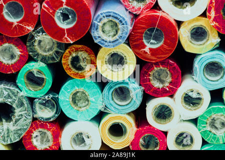 Rolls of colored wrapping paper on counter of store. Holiday and scrapbooking goods Stock Photo