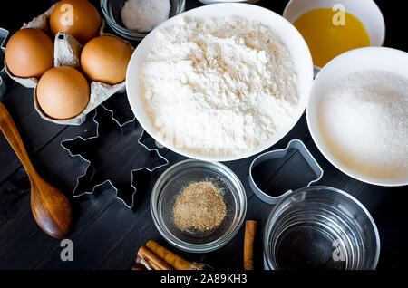 Set of ingredients for cooking festive Christmas gingerbread cookies - butter, flour, sugar, eggs, spices with  sugar decor, icing, forms for biscuits Stock Photo