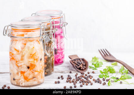 Homemade marinated sauerkraut sour in glass jars on rustic wooden kitchen table Stock Photo