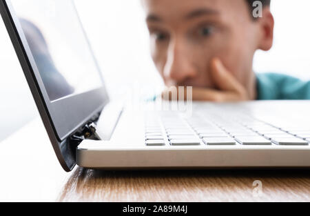 Man Looking At Damaged Laptop Computer With Broken Screen Attachment Stock Photo