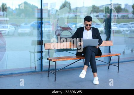 Cool guy arabic man uses laptop business center Stock Photo