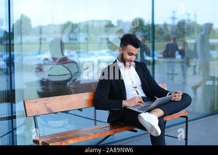 Cool guy arabic man uses laptop business center Stock Photo