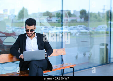 Cool guy arabic man uses laptop business center Stock Photo
