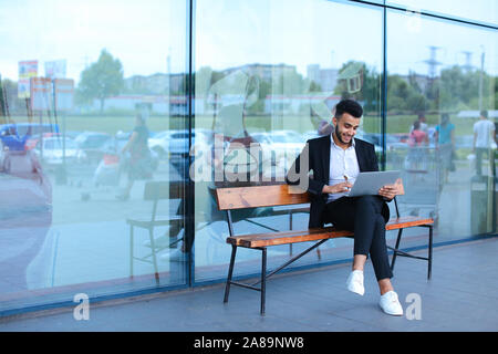 Cool guy arabic man uses laptop business center Stock Photo