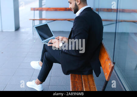 Cool guy arabic man uses laptop business center Stock Photo