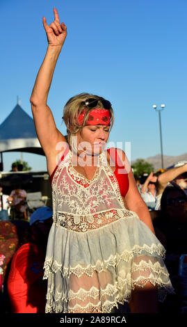 Concert goer dancing to music in the audience in front of stage Stock Photo