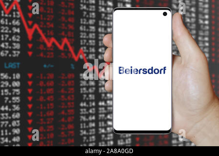 Logo of public company Beiersdorf displayed on a smartphone. Negative stock market background. Credit: PIXDUCE Stock Photo