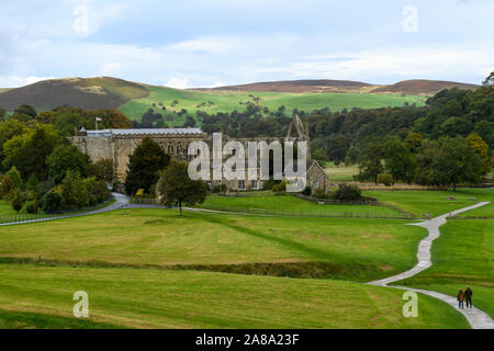 Ancient picturesque monastic Bolton Abbey ruins, Priory Church, Old Rectory & people on winding path - scenic rural view, Yorkshire Dales, England, UK Stock Photo