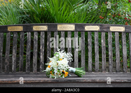 A bunch of flowers upon a memorial bench left by her daughter Kate on her wedding day. (Centre Plaque) Stock Photo