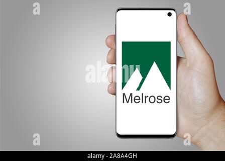 Logo of public company Melrose Industries displayed on a smartphone. Grey background. Credit: PIXDUCE Stock Photo