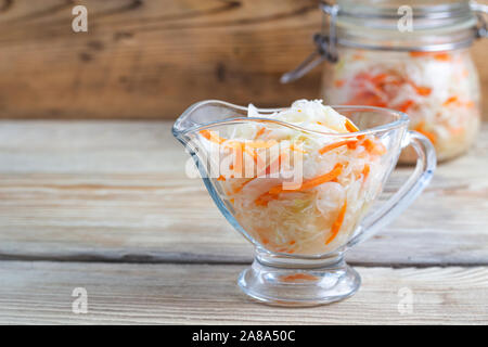 fermented cabbage in plate jars on a wooden table Stock Photo