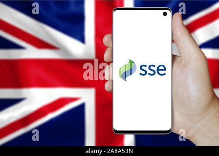 Logo of public company SSE plc displayed on a smartphone. Flag of UK background. Credit: PIXDUCE Stock Photo