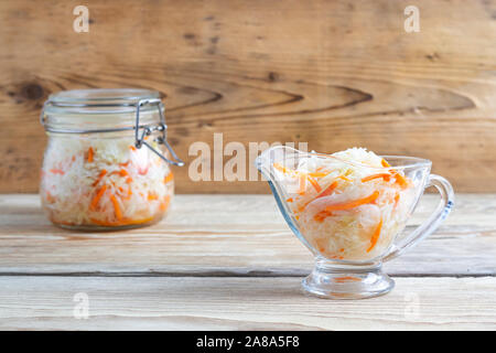 fermented cabbage in plate jars on a wooden table Stock Photo