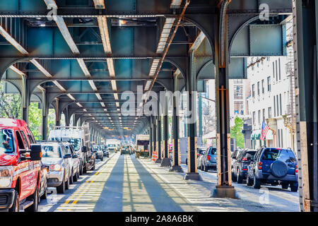 Bottom view of Elevated train track nyc. Traffic waiting in road in a sunny day. Travel and traffic concepts. Bronx, NYC, USA. Stock Photo
