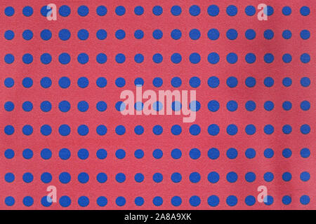 Blue dots on red background grainy wall pattern Stock Photo