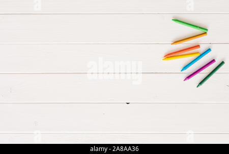 Top view of crayons on white wooden background Stock Photo