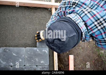 Man Laying Patio Paver Stones, Building Patio, Landscaping, Authentic Construction, MR Stock Photo