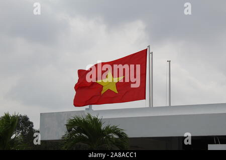 The Vietnamese flag flying in the wind on top of a building in Ho Chi Minh City, Vietnam. Stock Photo