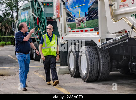 Tim Dolan, Waste Pro Regional Vice President for Central Florida, points out a new truck wrap to operations specialist Terry Grady in Sanford, Florida. Stock Photo