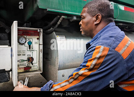 A diesel mechanic checks the control panel of a CNG-powered (compressed natural gas) Mack Truck at Waste Pro in Jacksonville, Florida. Stock Photo