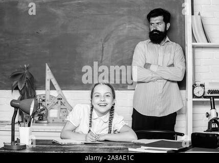 knowledge day. Home schooling. daughter study with father. Teachers day. education child development. bearded man teacher with small girl in classroom. back to school. Science and education. Stock Photo