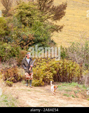 Frenchman out hunting with a shotgun and his gun dog in the French countryside in the Languedoc region of France during Autumn Stock Photo