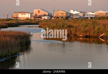 The sun sets on a row of houses along Louisiana Highway 1 on March 6, 2011 in Grand Isle, Louisiana. Stock Photo