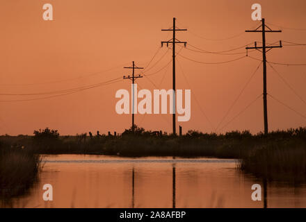 The sun sets on Grand Isle, a barrier island situated on the Gulf of Mexico at the southernmost tip of Louisiana, Nov. 23, 2010. Stock Photo