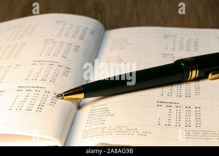 Pen lying on calendar or organizer on desk in office Stock Photo