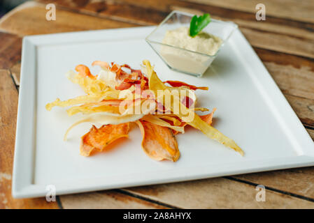 hummus with root vegetable color chips in restaurant Stock Photo