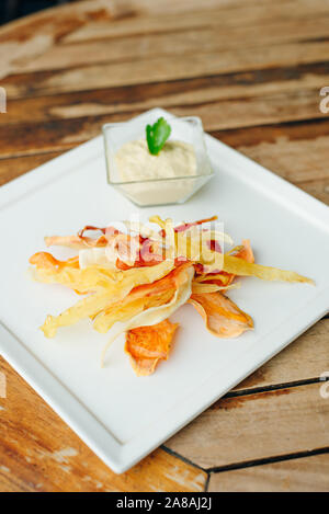 hummus with root vegetable color chips in restaurant Stock Photo