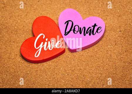 Heart shaped with give and donate words on cork bulletin board Stock Photo