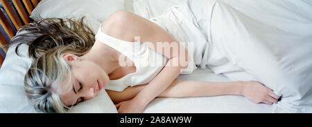 Young beautiful woman sleeping in bed, USA Stock Photo