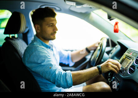 Man is going to drive, looking for some nice music Stock Photo