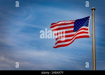 The American flag waves in the  wind. Stock Photo