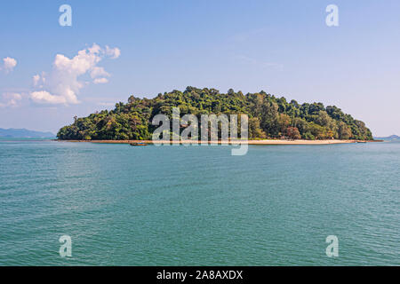 Small typical boat of the place sailing in front of an atoll in the Andaman Sea. thailand Stock Photo