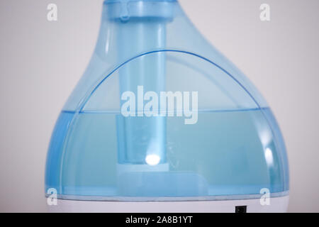 Air humidifier on a bright white background. Blue humidifier in close-up. The concept of taking care of the air, cleansing the air and moisturizing du Stock Photo