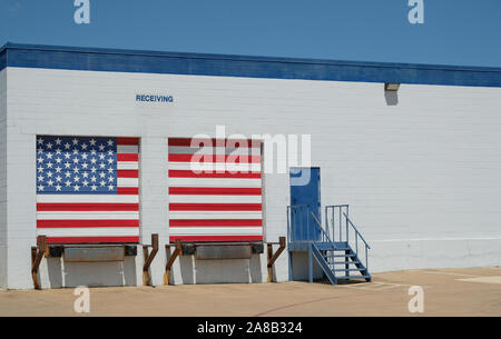 Warehouse with american flag painted receiving docks / Logistics building with entrance door and white and blue brick wall with copy space Stock Photo