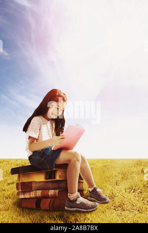 Cute little schoolgirl with book on white background Stock Photo - Alamy