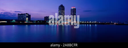 Buildings lit up at the waterfront, Torre Mapfre, Hotel Arts, Port Olimpic, Barcelona, Catalonia, Spain Stock Photo