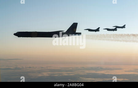 Royal Norwegian Air Force F-16 Fighting Falcon aircraft fly alongside assigned a U.S. Air Force B-52H Stratofortress strategic bomber during joint training with the Norwegian Air Force November 6, 2019 over the Barents Sea, Norway.