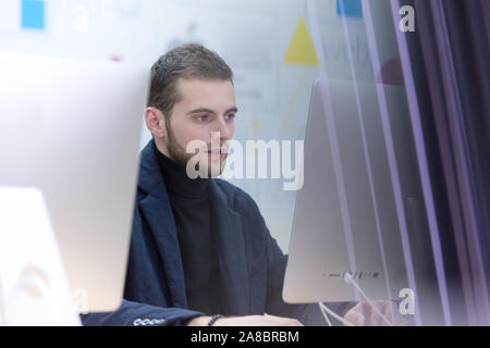 Young male Businessman working on modern computer. Businessman using innovative technologies. Businessman working on computer, software developing wit Stock Photo
