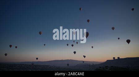 Sunrise panoramic view to Goreme city and flying balloons over pigeon valley Cappadocia, Turkey Stock Photo