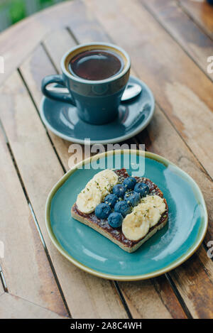 toast with chocolate paste, bananas and blueberries on the blue plate Stock Photo